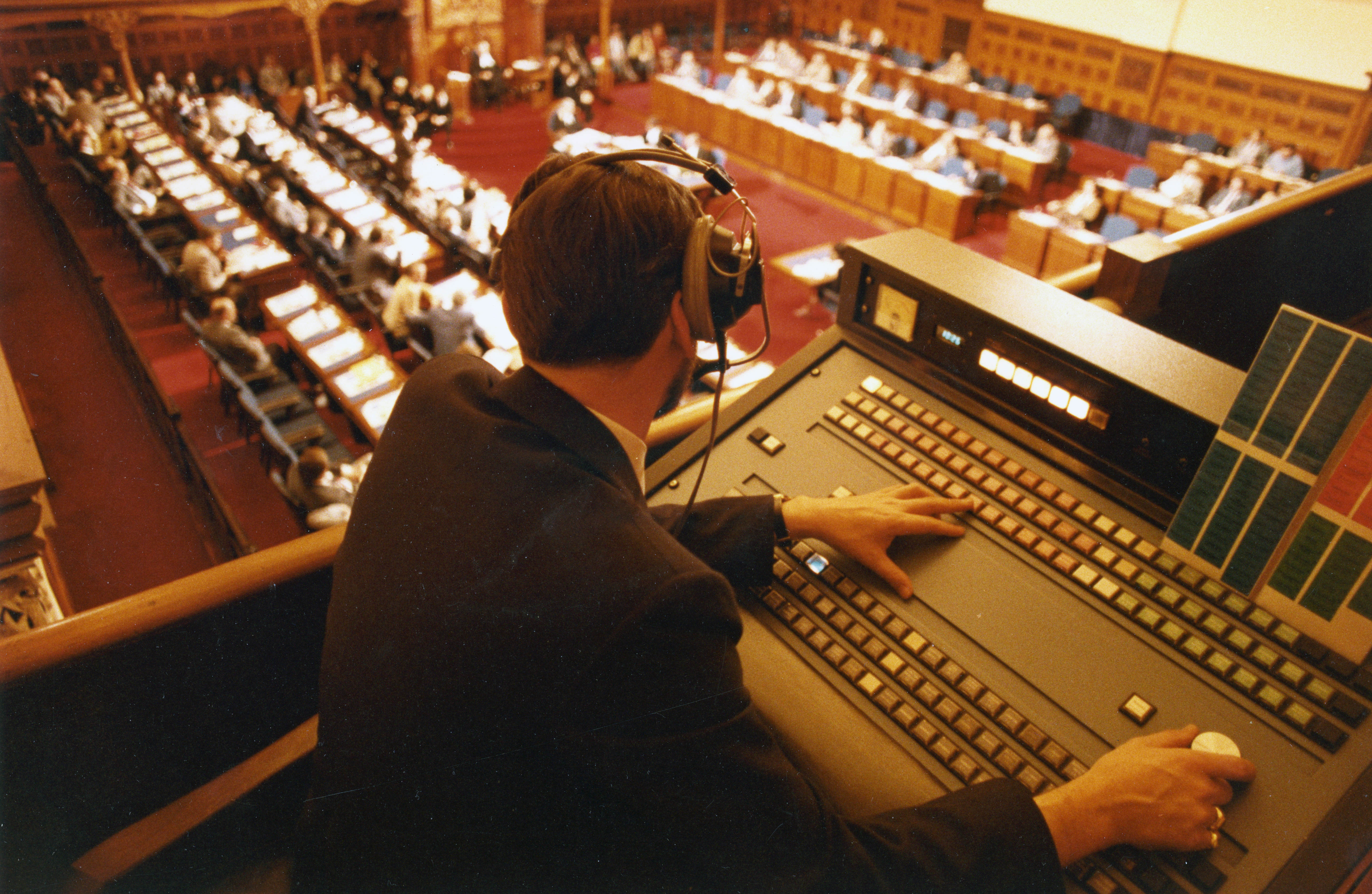 broadcast operator operating sound board above the legislative Chamber