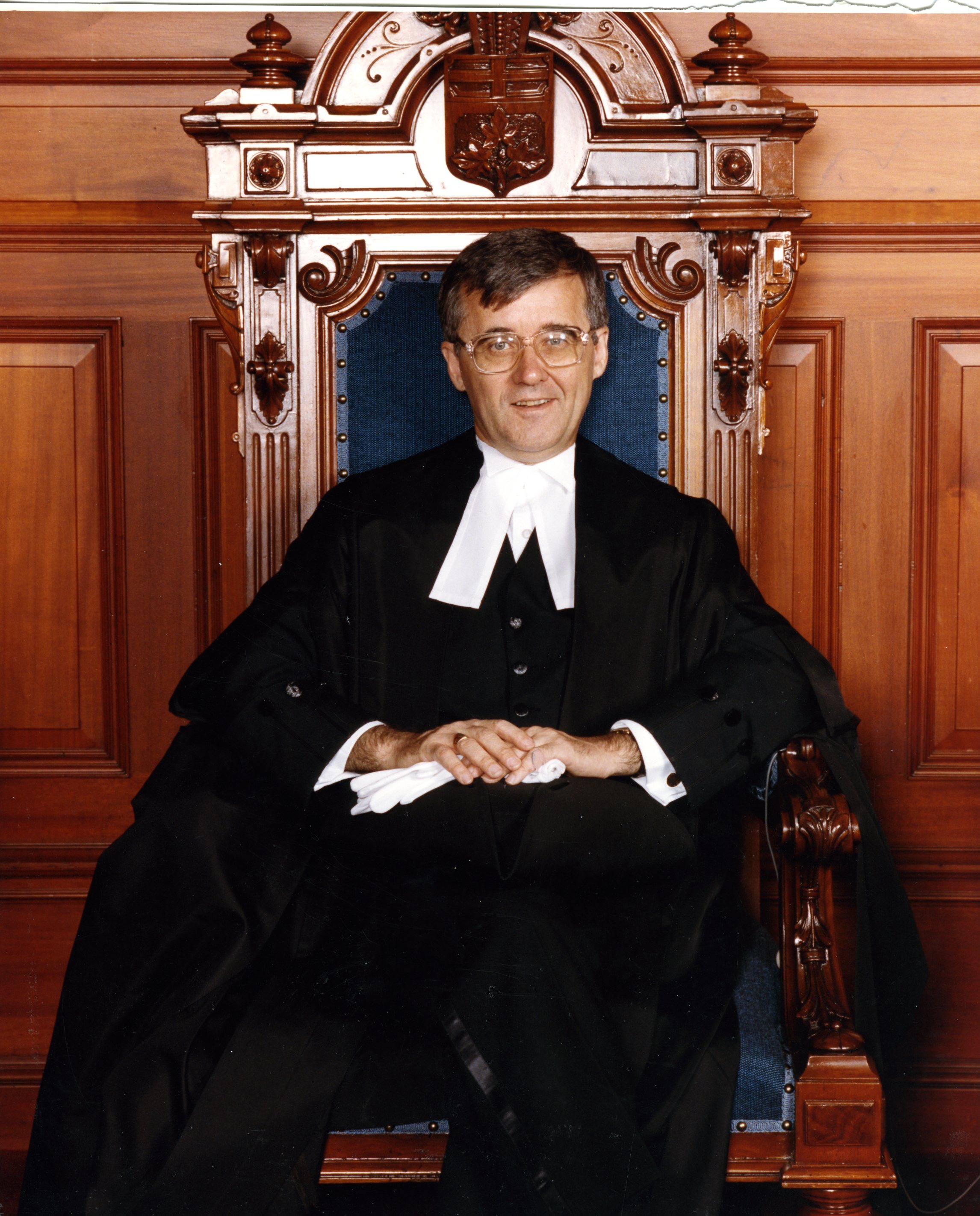 Speaker in black and white robe sitting in Speaker's chair