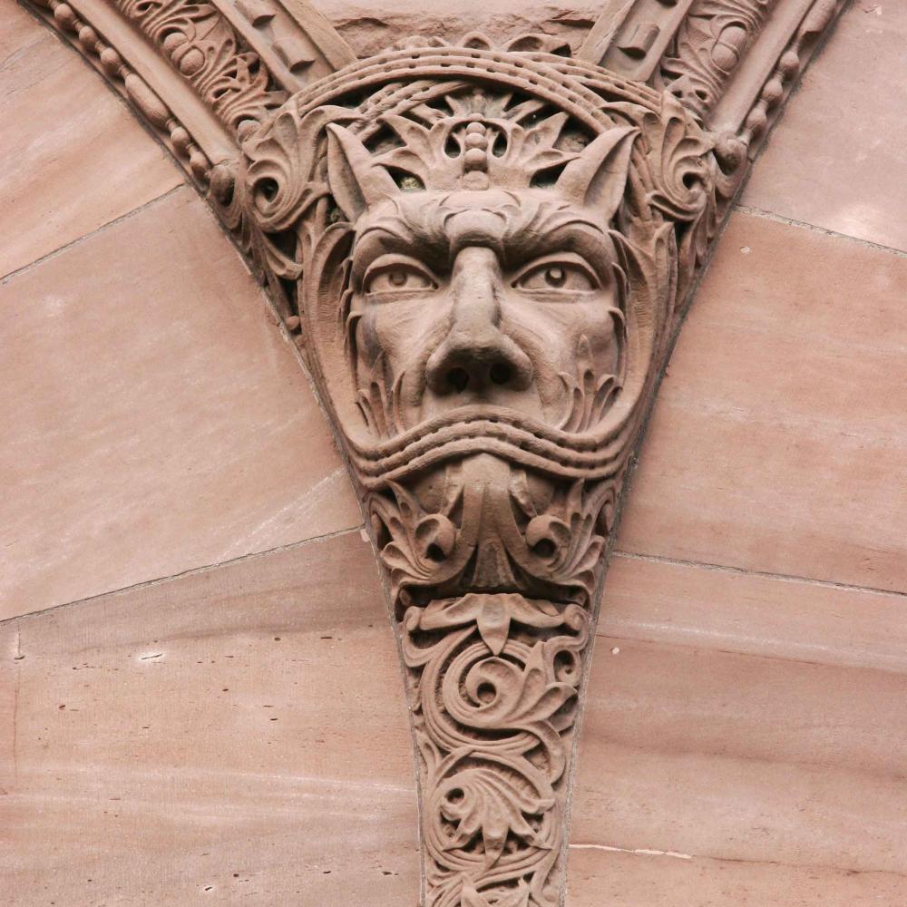 Sandstone carving of a gargoyle-like face on the outside of the Legislative building