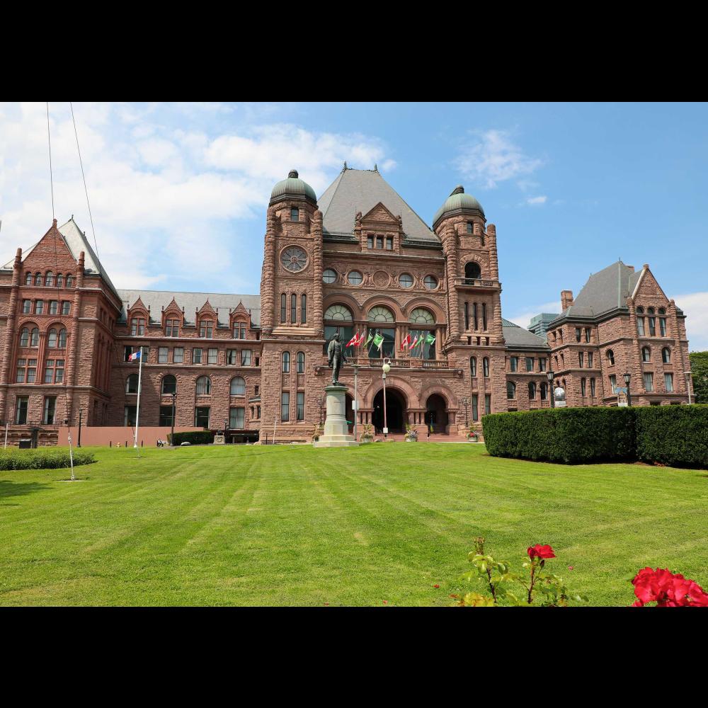 A front view of the Legislative building and green lawn in spring